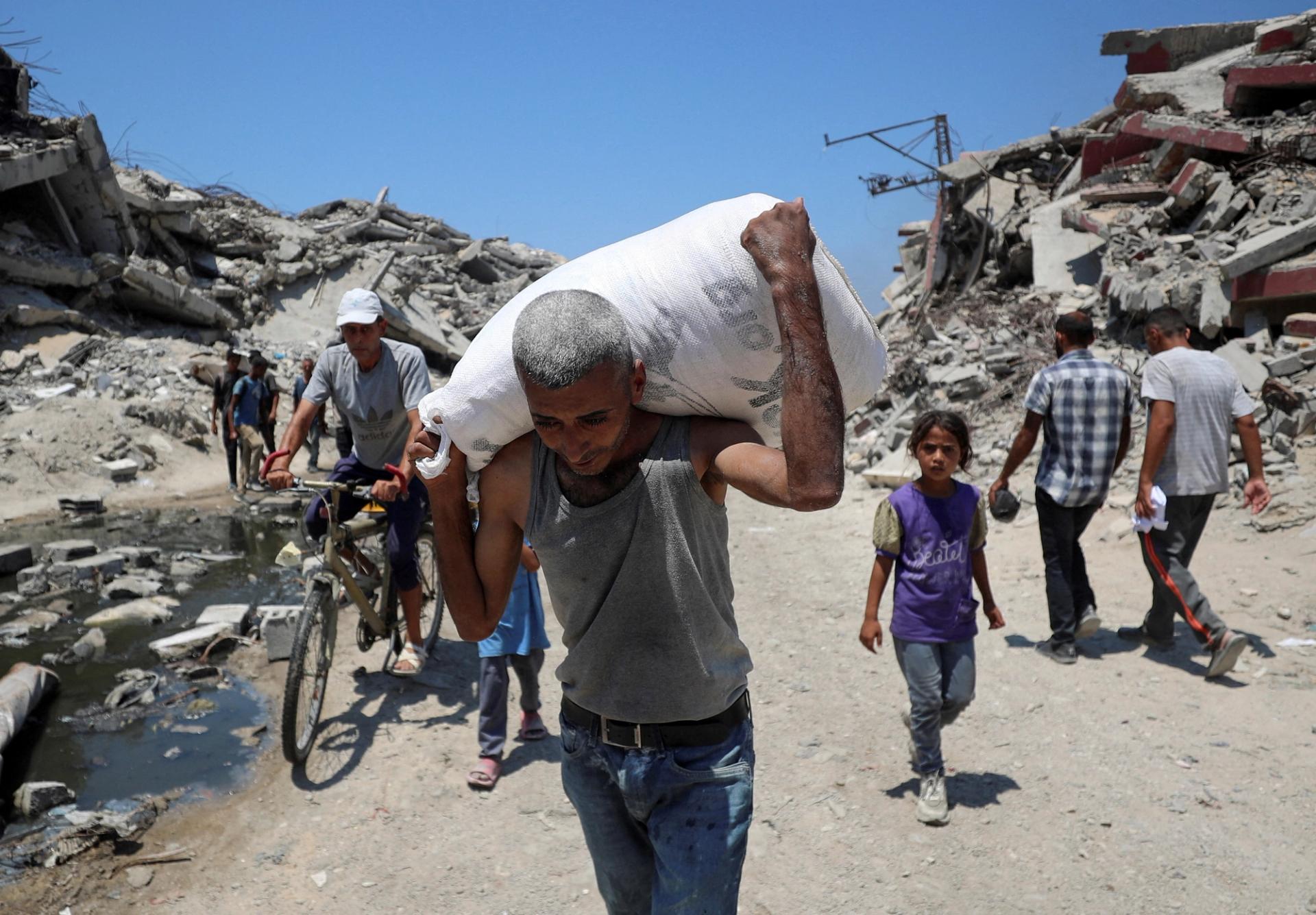 A Palestinian carries a bag with aid supplies that entered Gaza through Israel, in Beit Lahia.