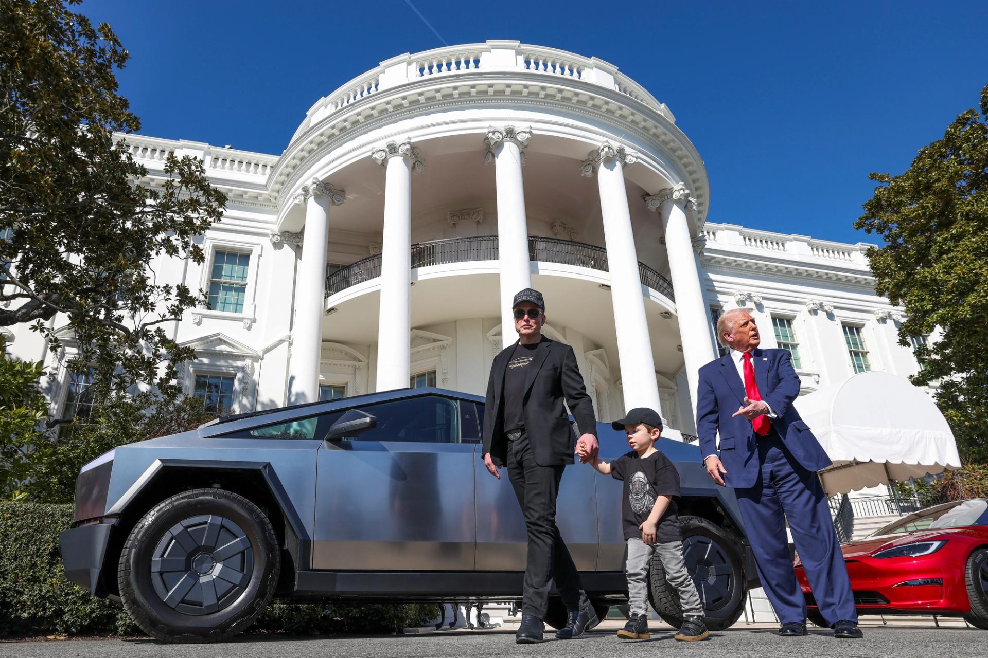 U.S. President Donald Trump talks to the media, next to Tesla CEO Elon Musk with his son X Æ A-12 at the White House.