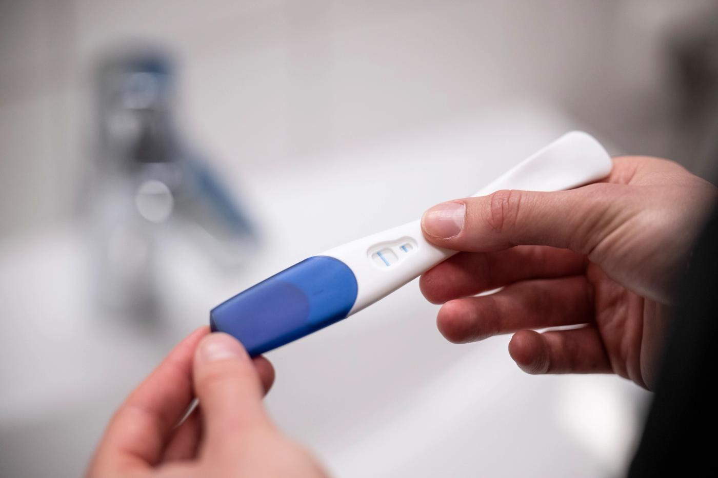 A woman holds a pregnancy test. 