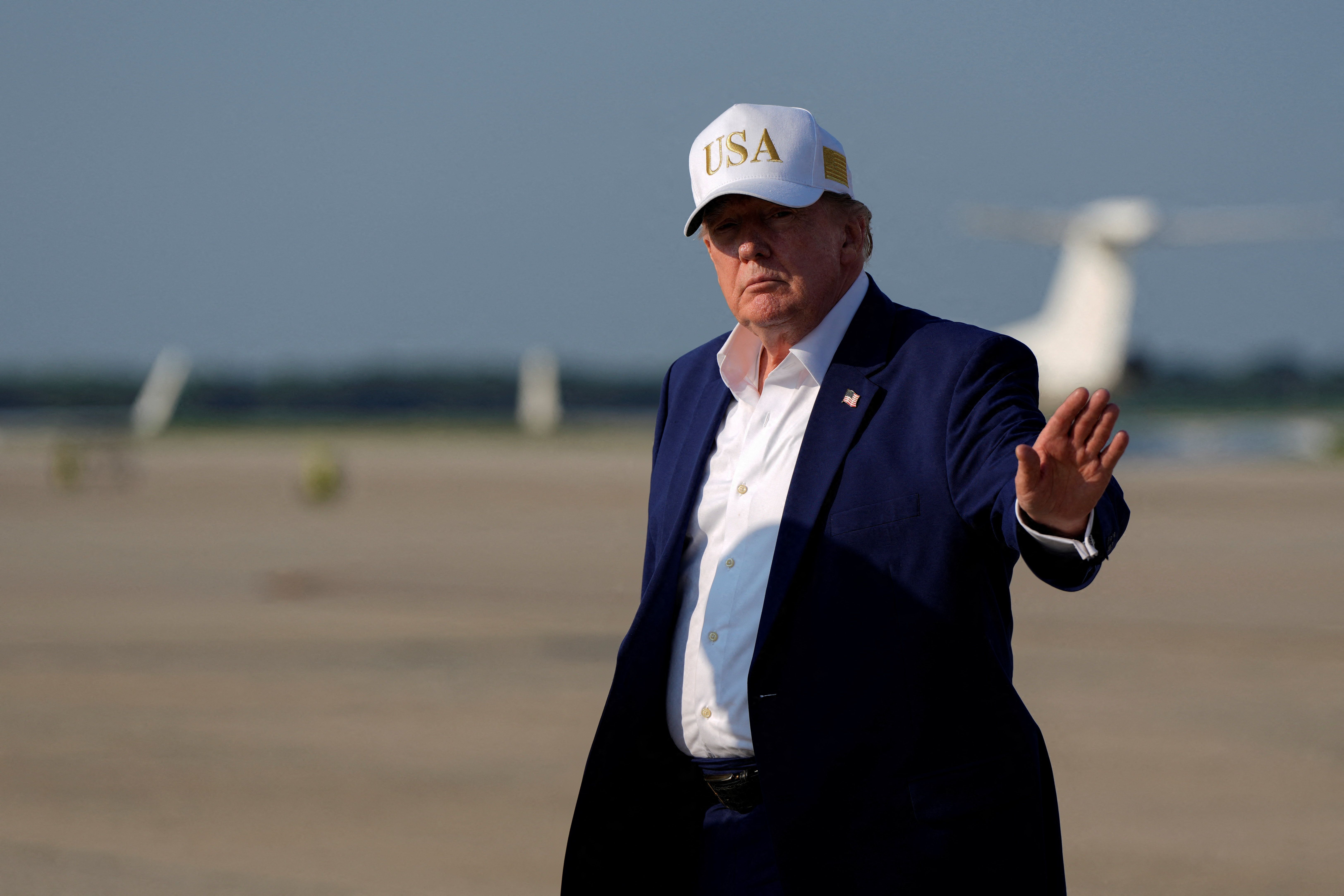 US President Donald Trump waves as he disembarks Air Force One at Joint Base Andrews, Maryland.