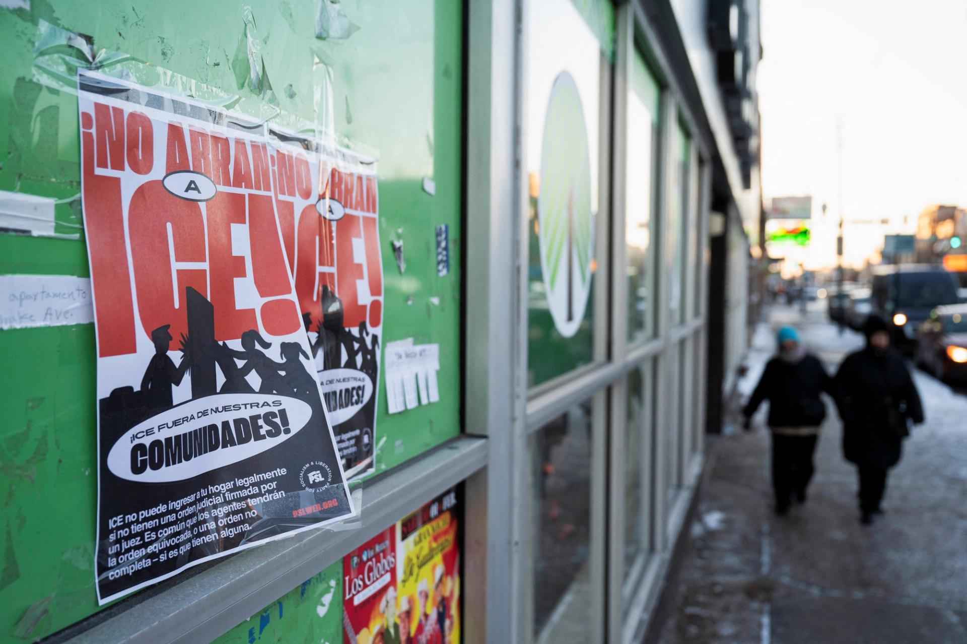 Signs related to President Donald Trump and Immigrations and Customs Enforcement (ICE) pasted on a storefront in the Little Village neighborhood of Chicago, Illinois