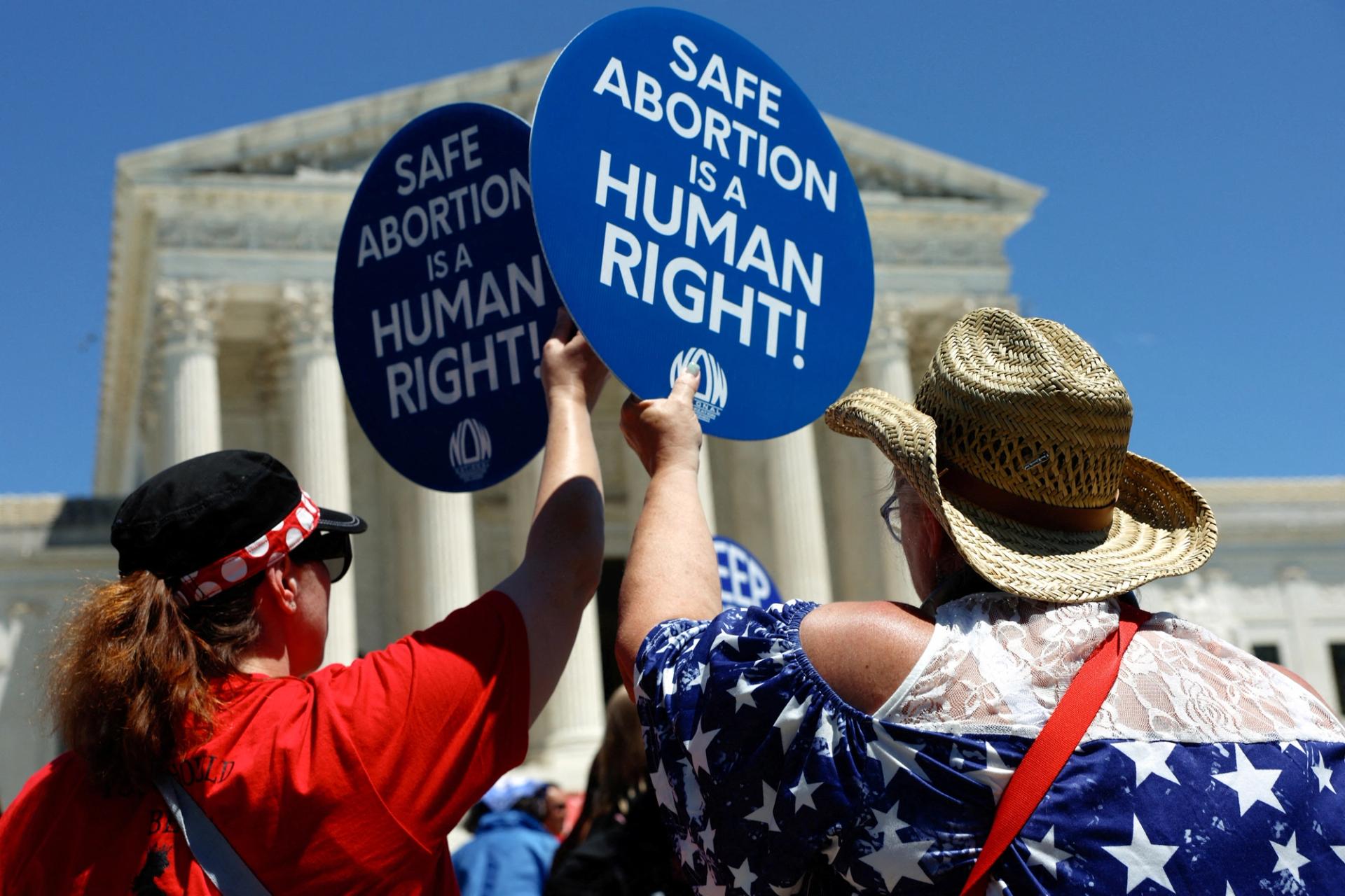 Abortion rights activists hold signs as they gather at the U.S. Supreme Court to mark the second anniversary of the Court overturning Roe v. Wade.
