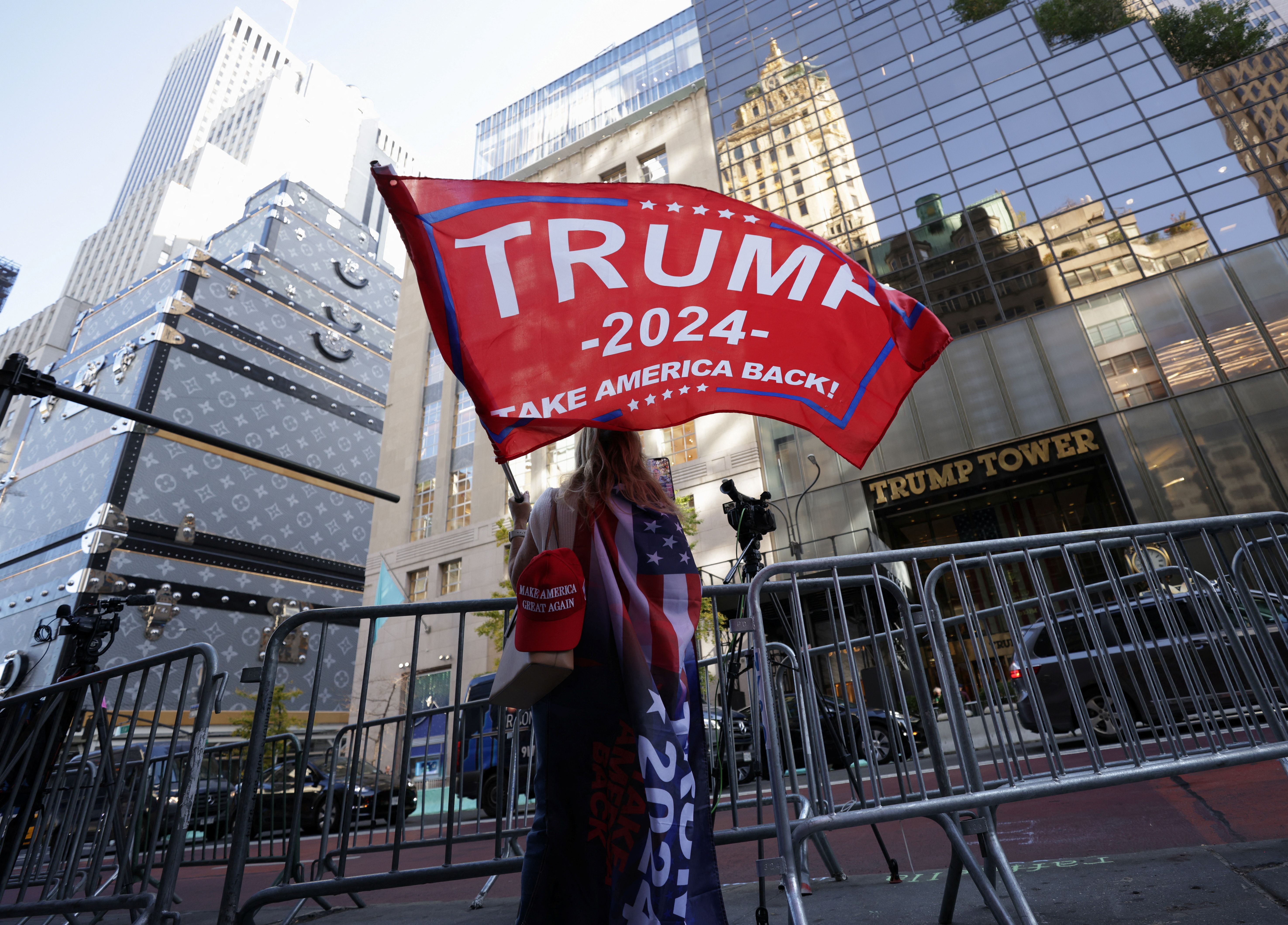A person waves a Trump flag outside Trump Tower.