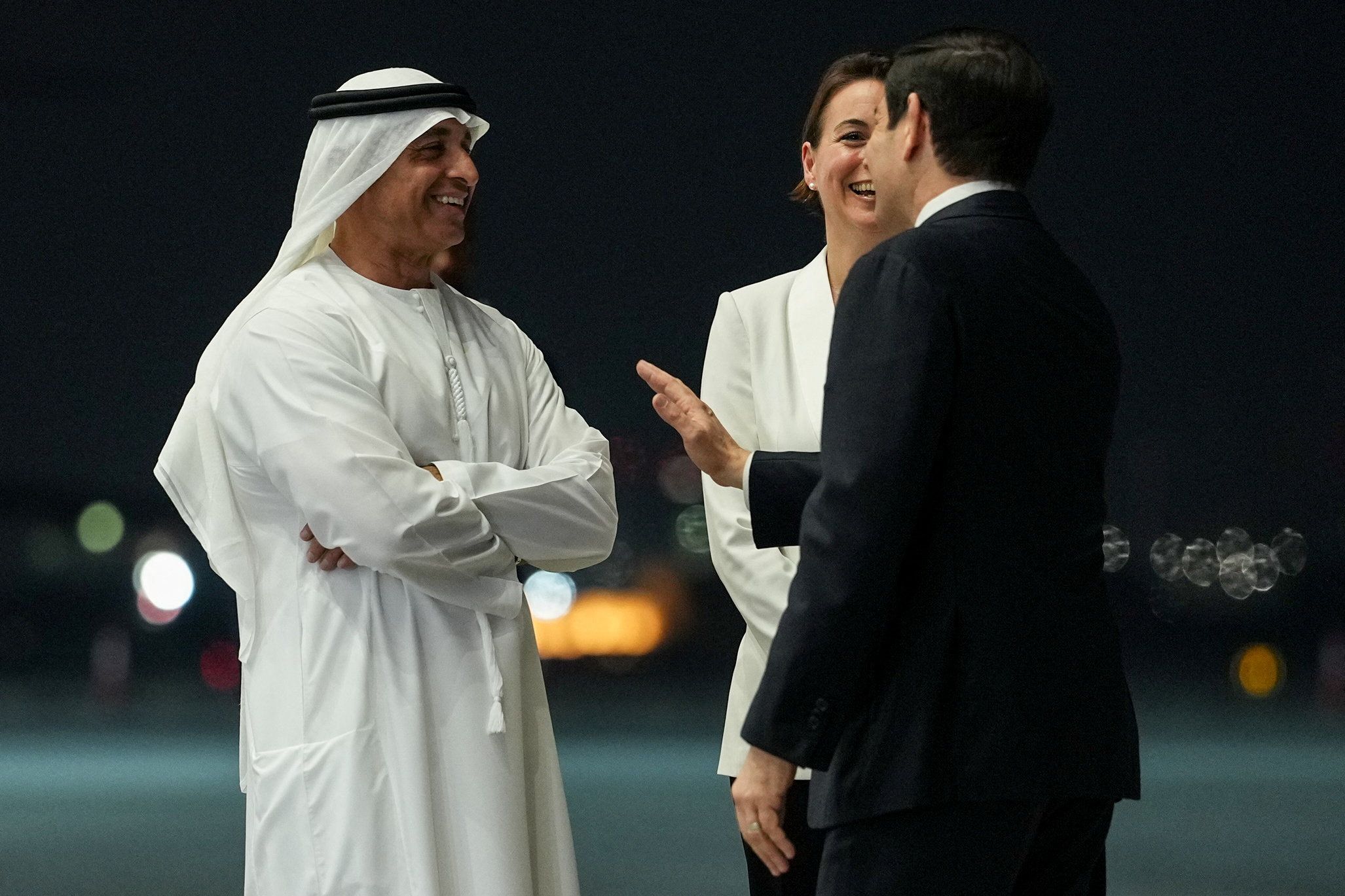 U.S. Secretary of State Marco Rubio speaks with UAE Ambassador to the U.S. Yousef Al Otaiba upon his arrival at Al Bateen Executive Airport.