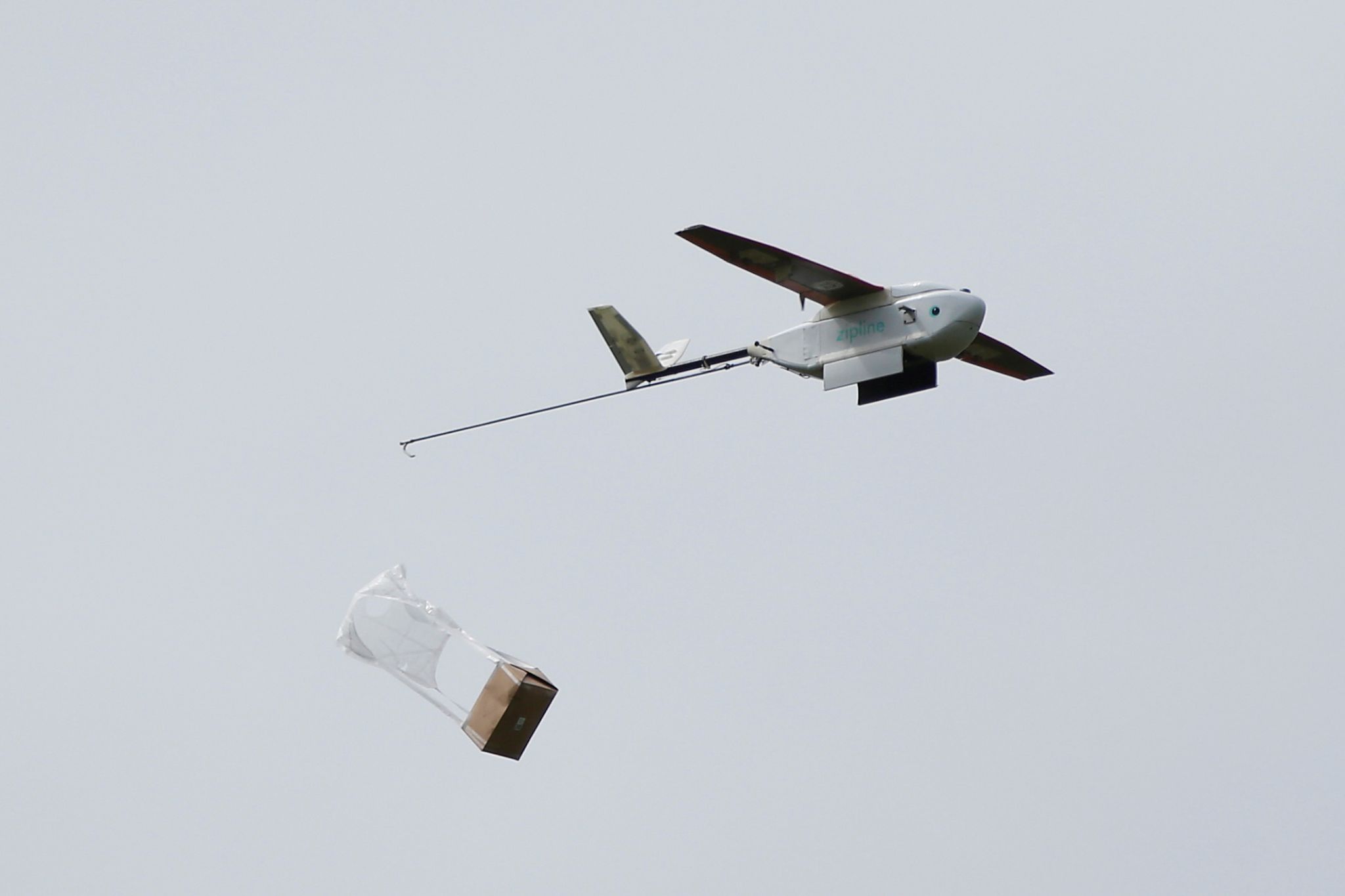 A Zipline delivery drone releases its payload mid