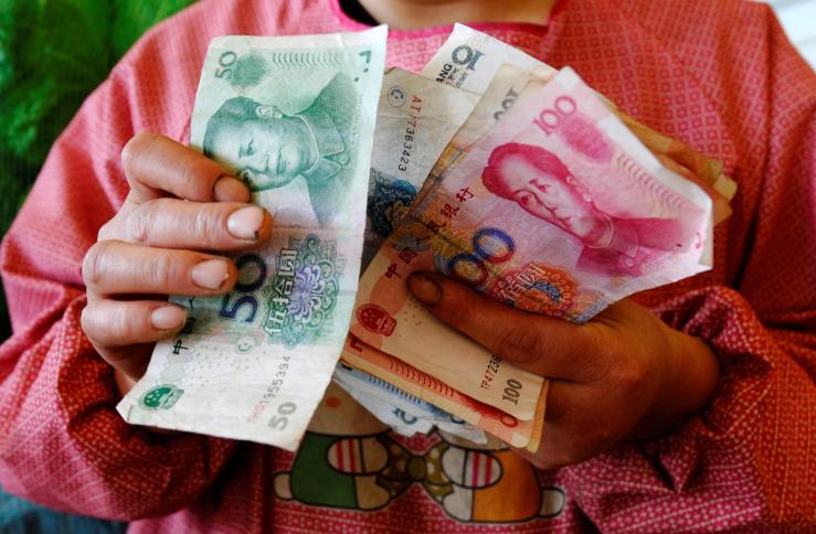 A vendor counts yuan banknotes.
