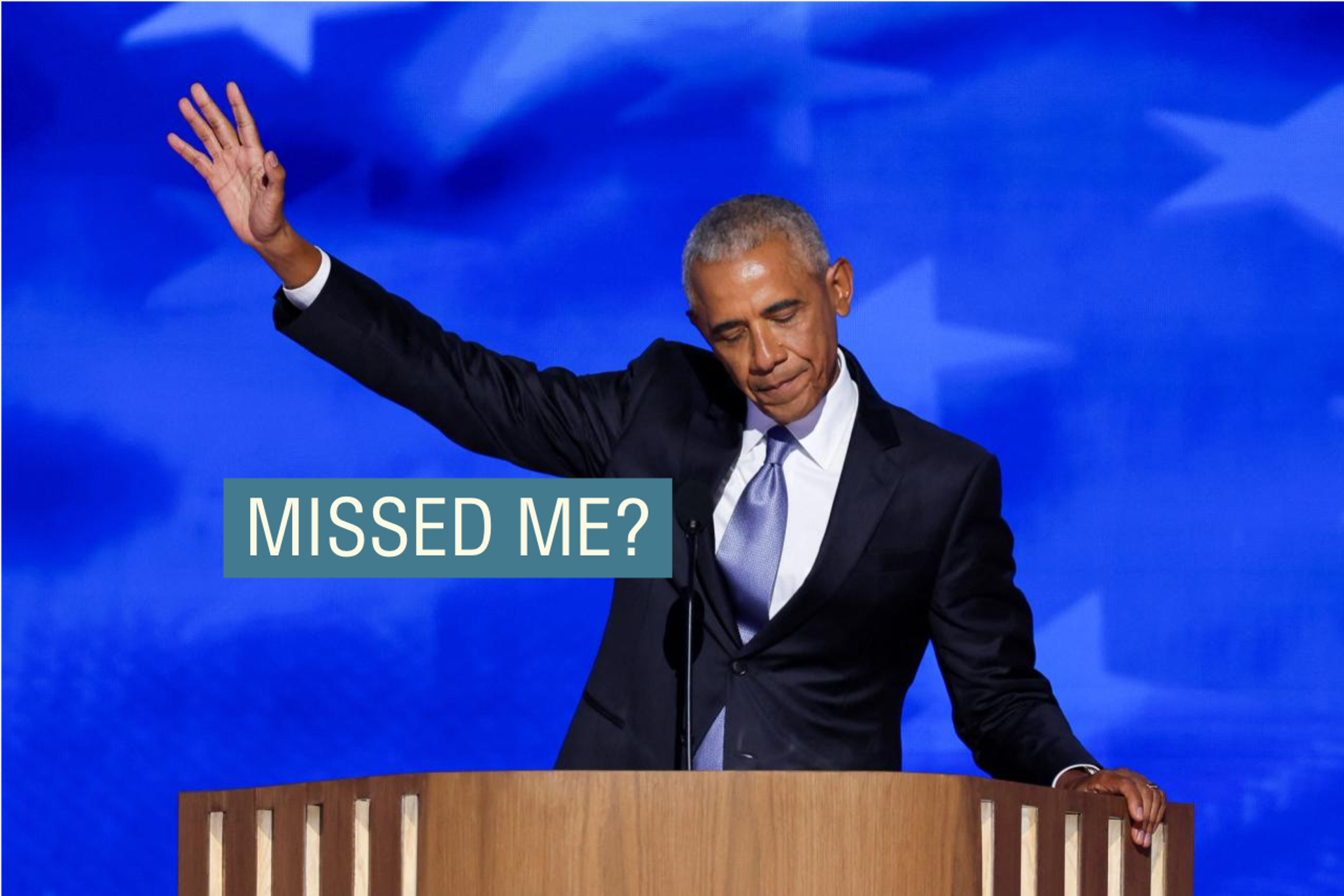 Barack Obama, in a dark suit and light tie, raises his hand dramatically while addressing the Democratic National Convention.