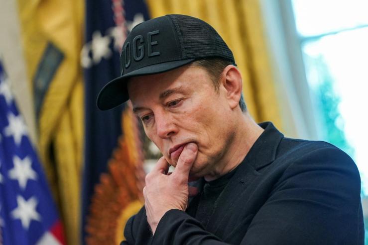 Elon Musk reacts during a White House press conference.