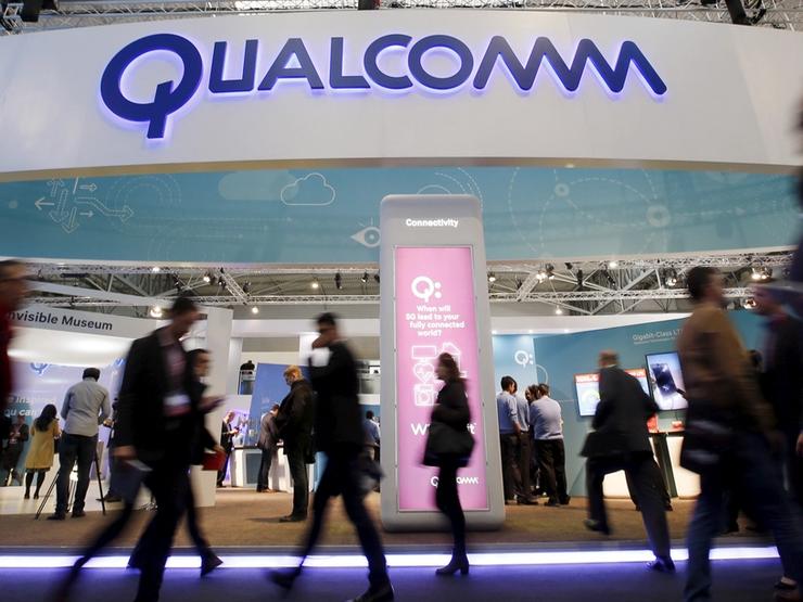 People walk past Qualcomm’s stand during the Mobile World Congress in Barcelona, Spain in this February 24, 2016.