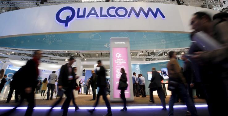 People walk past Qualcomm’s stand during the Mobile World Congress in Barcelona, Spain in this February 24, 2016.