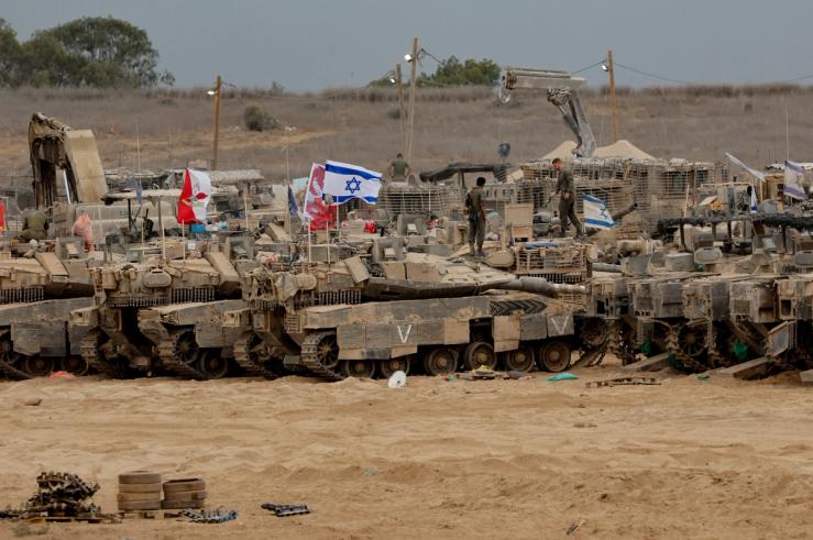 Israeli soldiers stand on military vehicles near the Israel-Gaza border