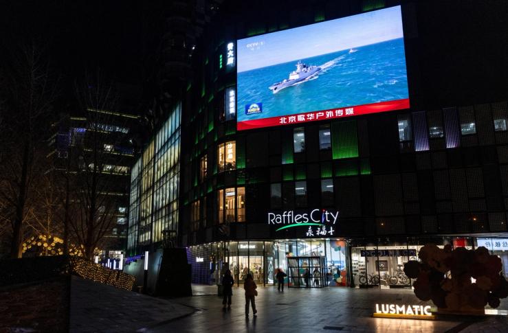 A large screen in Beijing shows a Chinese destroyer