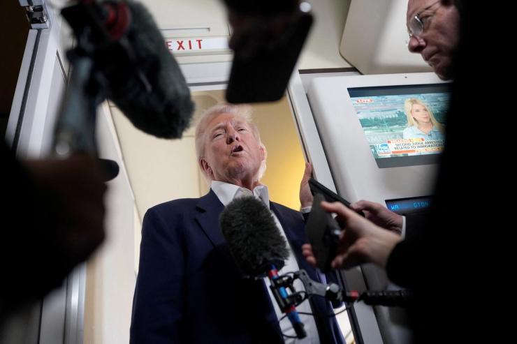 U.S President Donald Trump speaks to members of press onboard Air Force One.