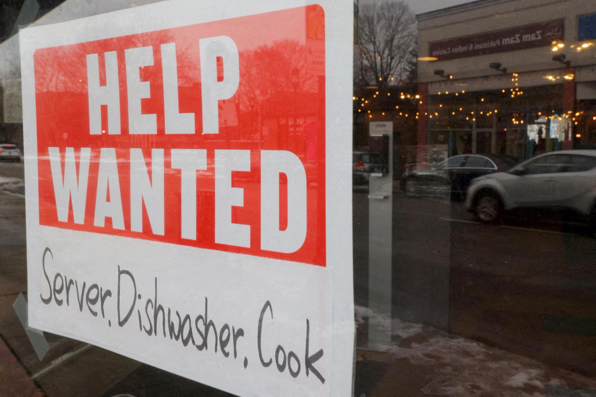 A “Help Wanted” sign hangs in restaurant window in Medford, US.