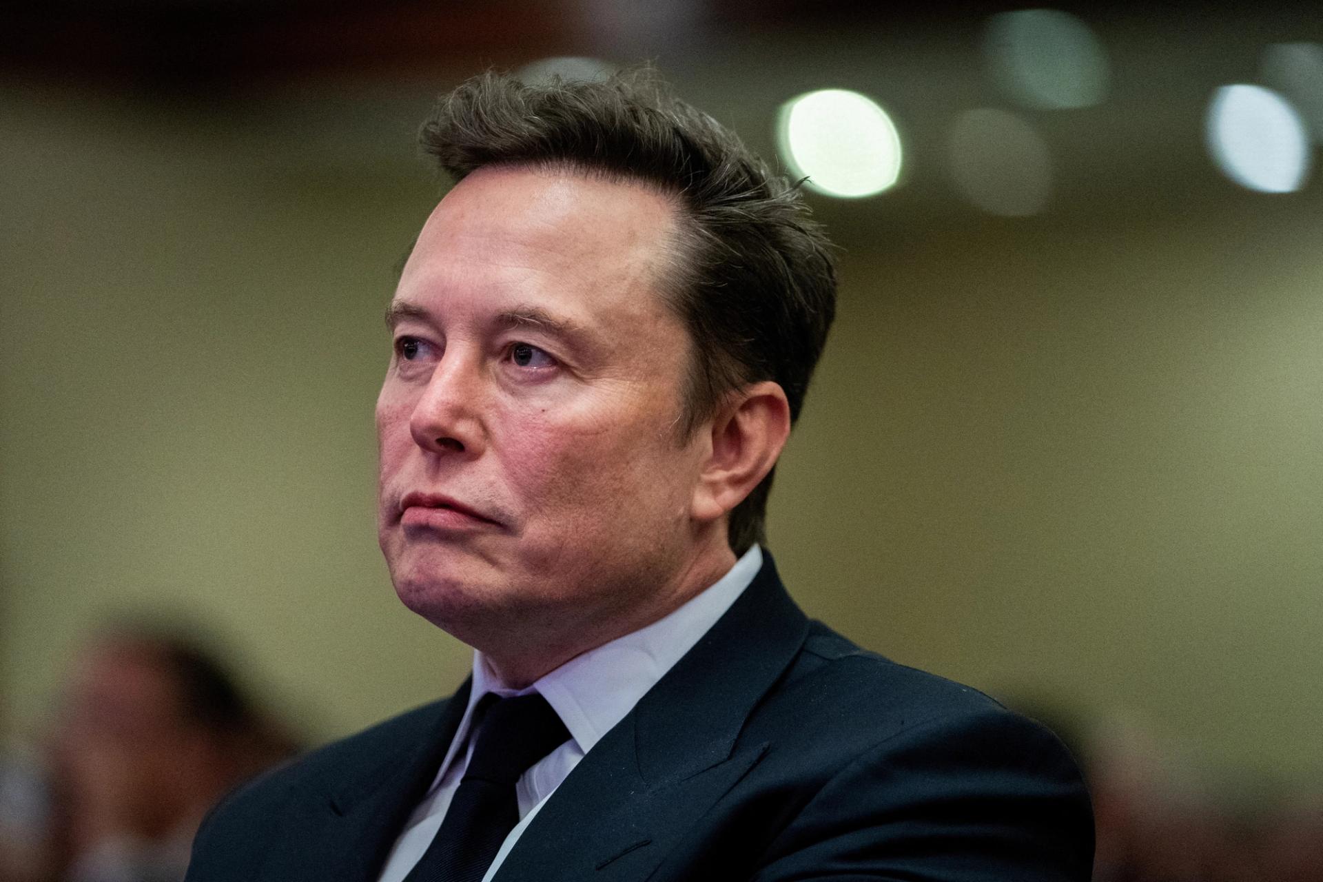 Tesla CEO and X owner Elon Musk listens as US President-elect Donald Trump speaks during a meeting with House Republicans at the Hyatt Regency hotel in Washington, DC