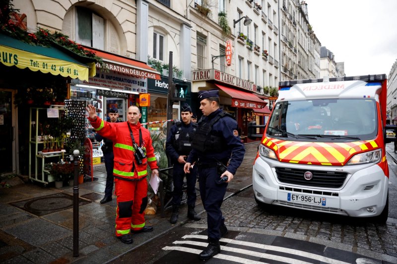 French police and firefighters secure a street after gunshots were fired killing two people and injuring several in a central district of Paris, France, December 23, 2022