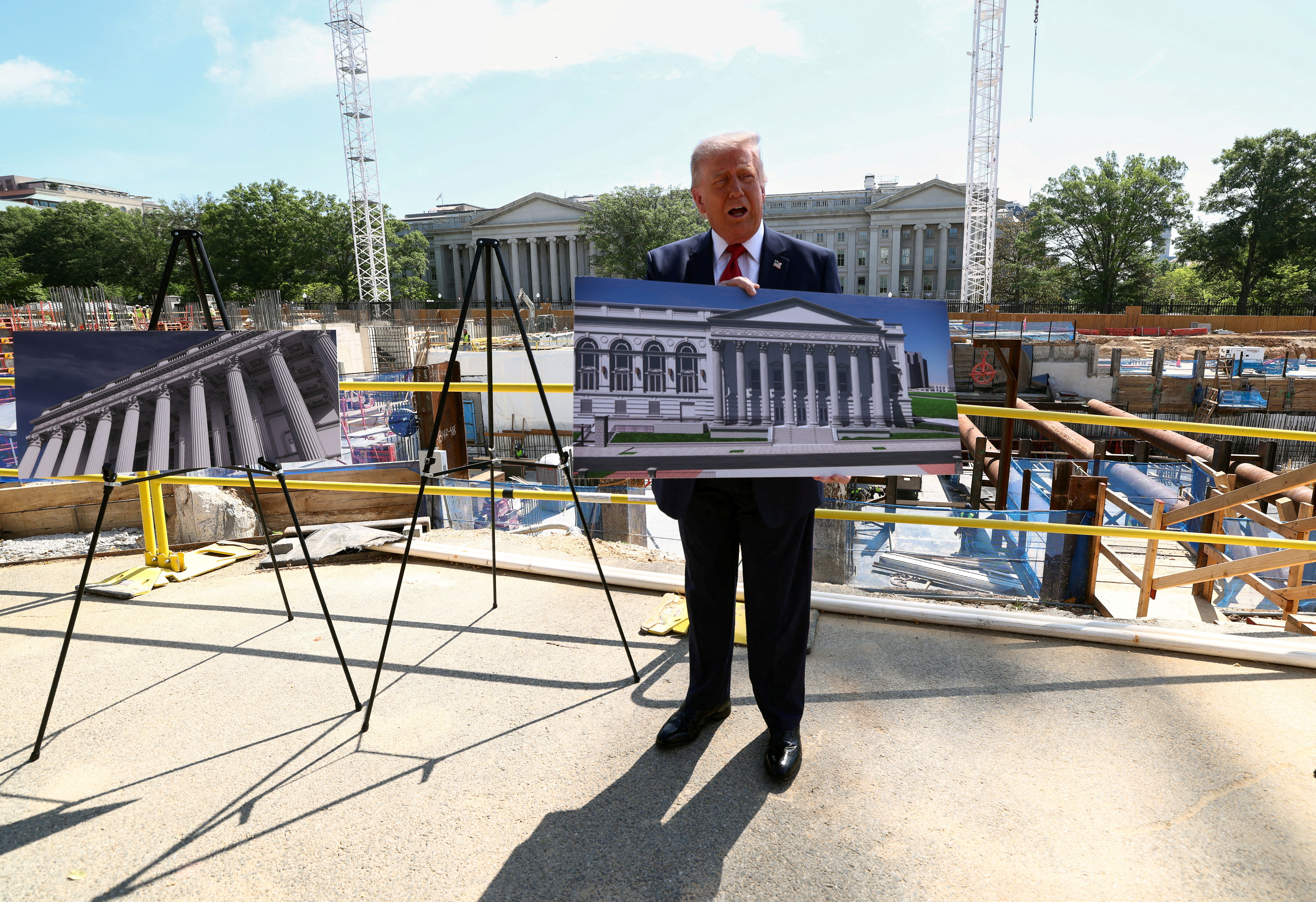 Donald Trump holding a render of the White House ballroom