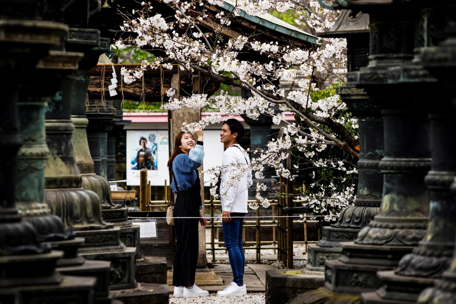 Young couple observe the cherry blossoms at Ueno park in Tokyo, Japan, March 21, 2023. REUTERS/Androniki Christodoulou