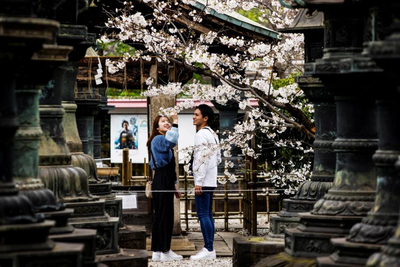 Young couple observe the cherry blossoms at Ueno park in Tokyo, Japan, March 21, 2023. REUTERS/Androniki Christodoulou