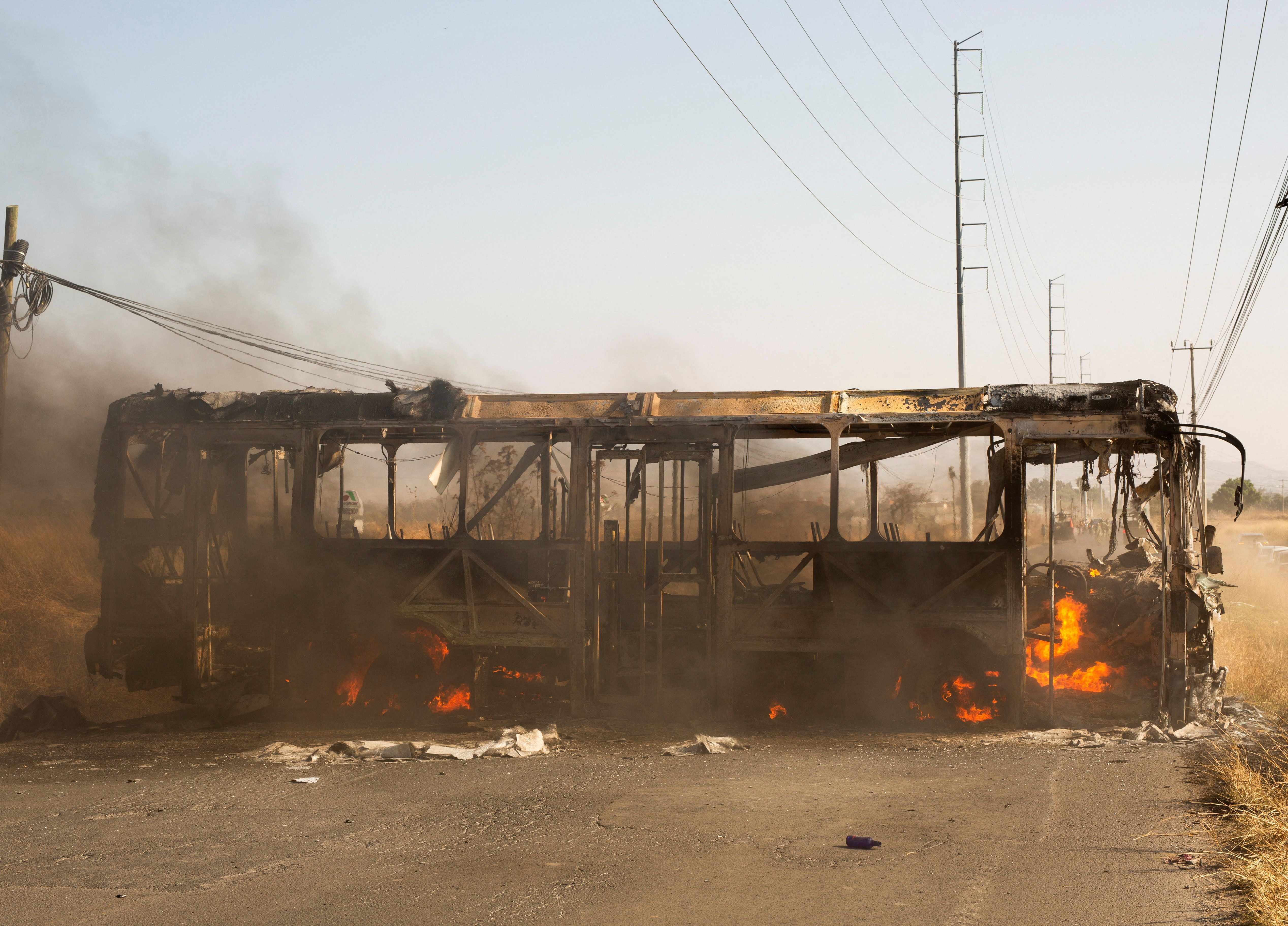  bus used as a roadblock by organized crime burns following a federal operation to kill an alleged Mexican drug lord