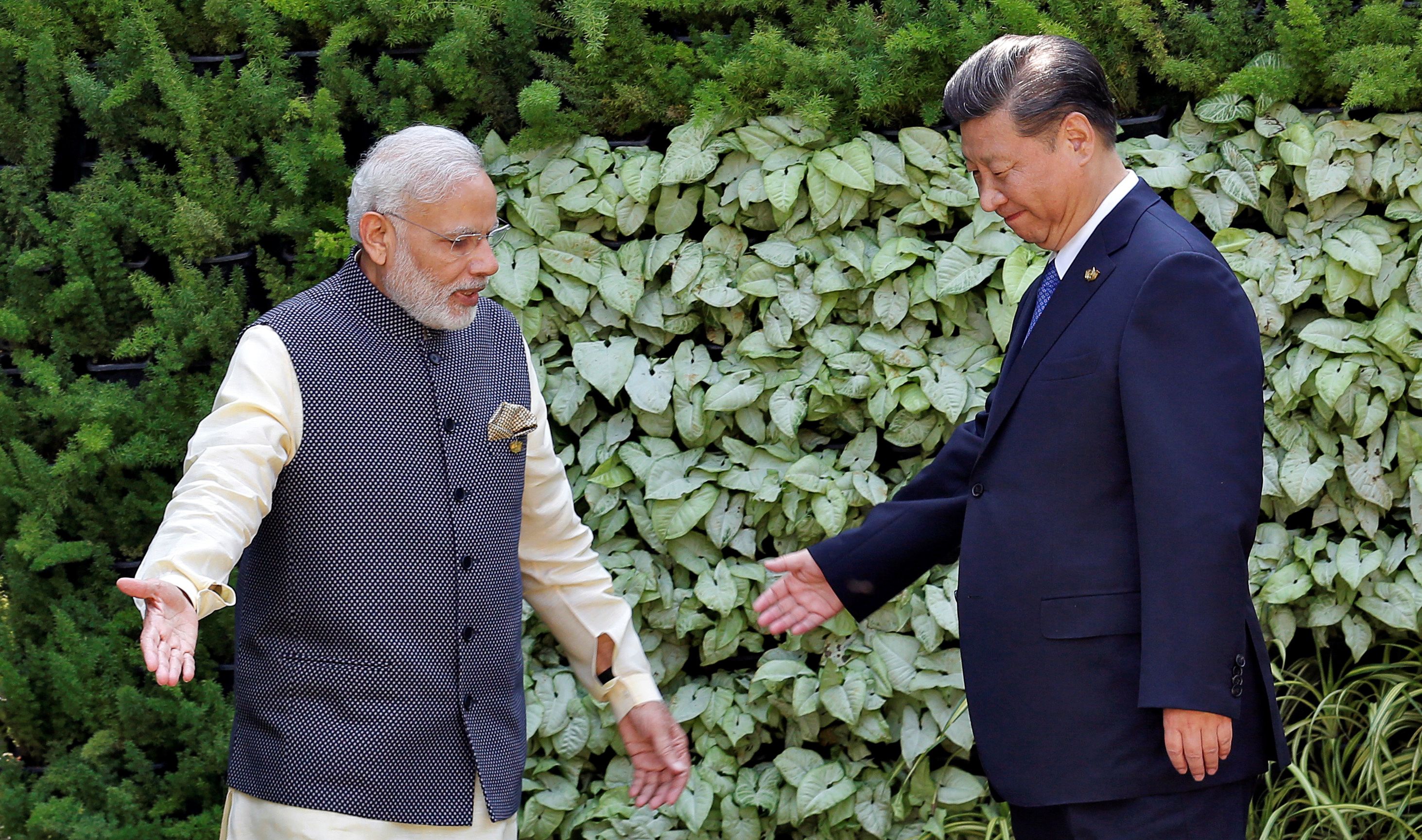 Indian Prime Minister Narendra Modi and Chinese leader Xi Jinping greet one another.