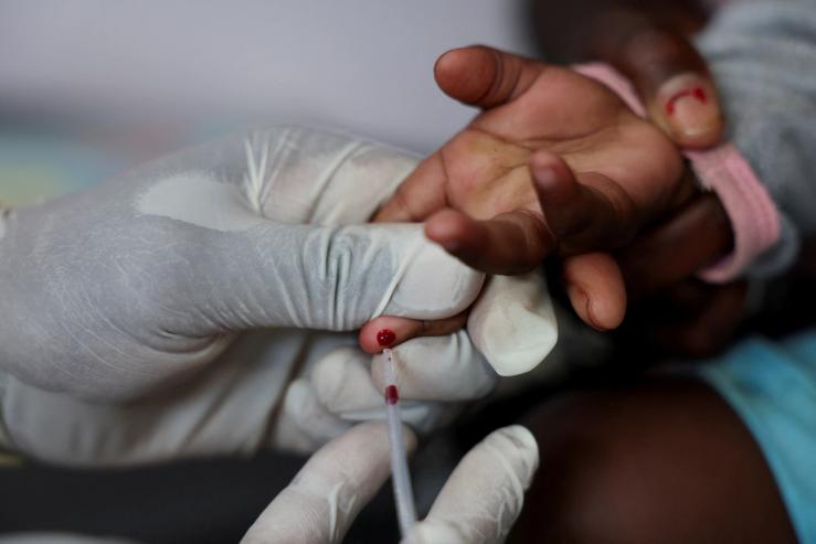 A nurse draws a blood sample from a child for an HIV test.