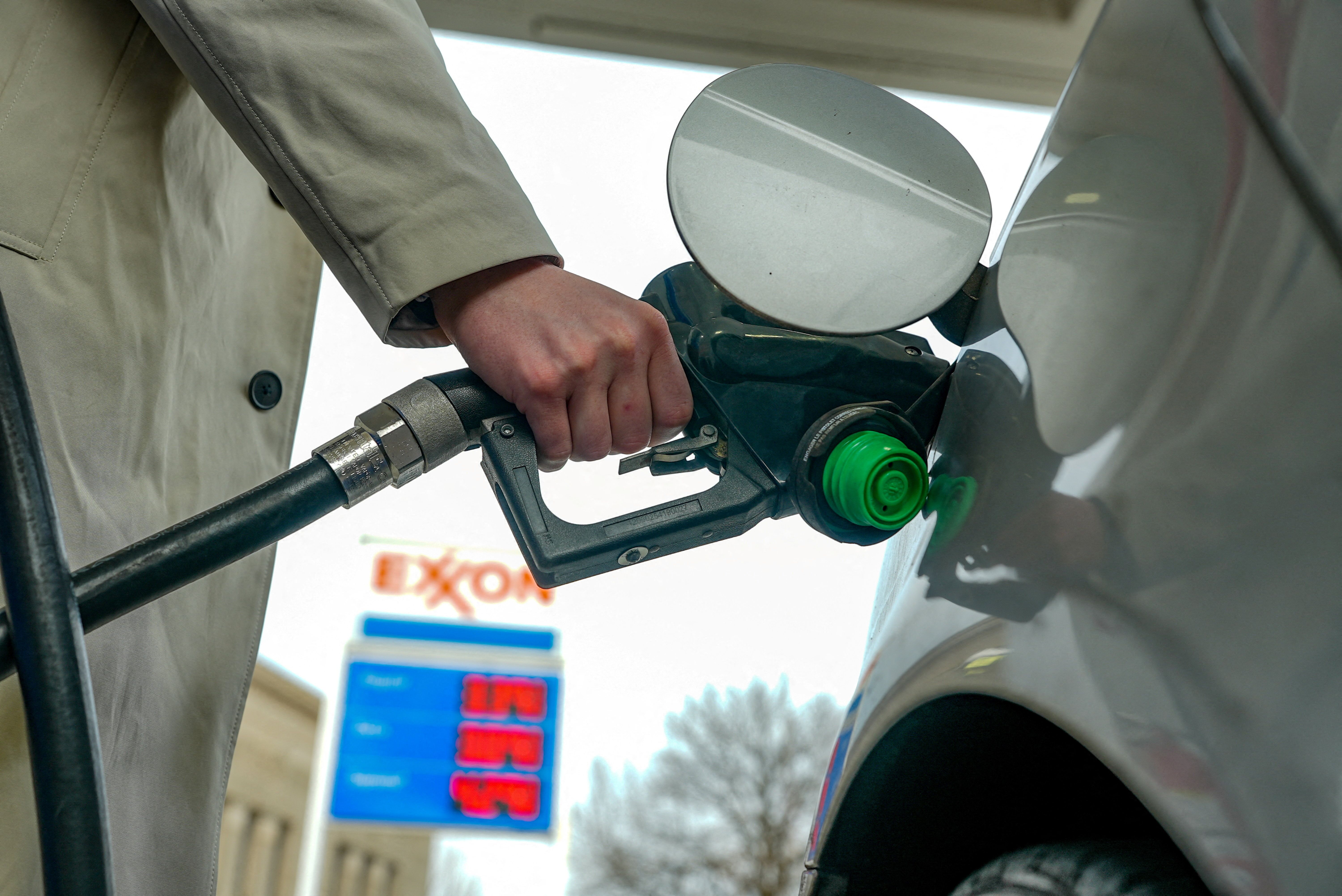 A man pumps gas at an Exxon station as the price of oil and gas has surged