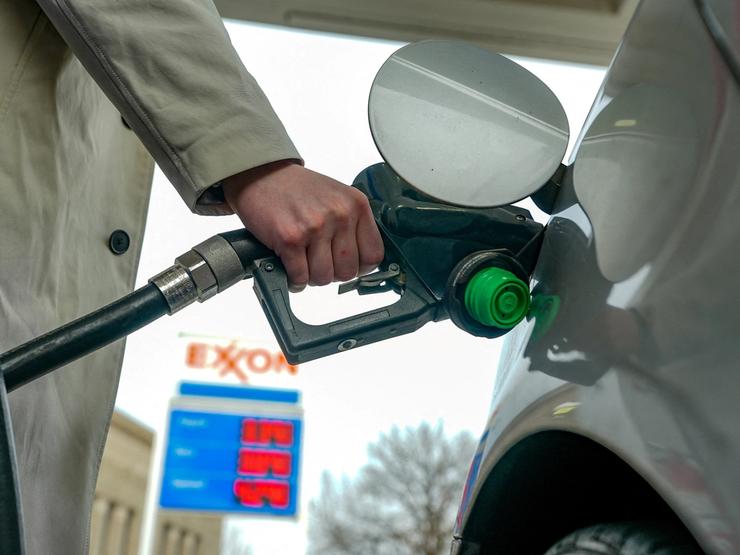 A man pumps gas at an Exxon station as the price of oil and gas has surged