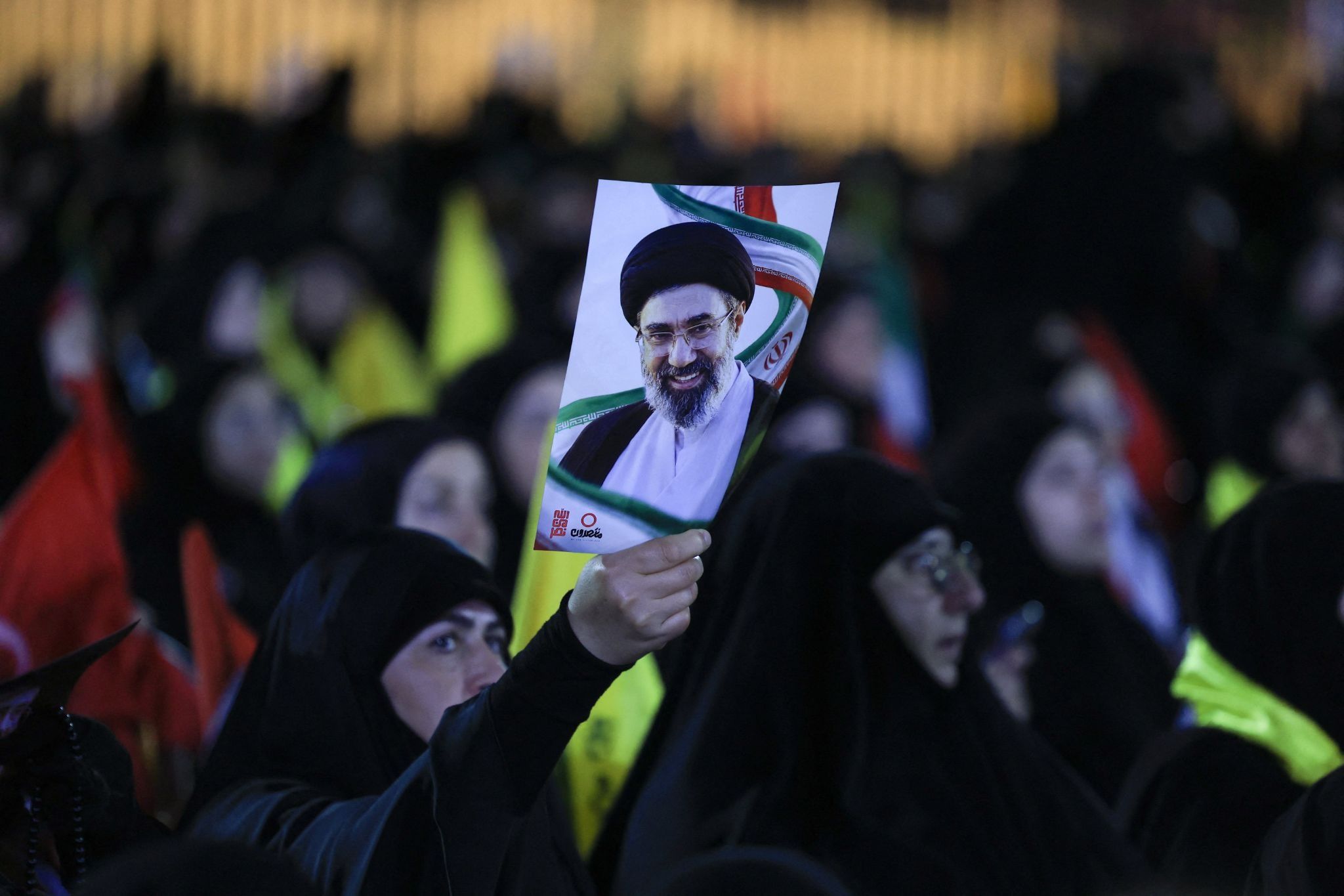 A person holds a portrait of Iran’s Supreme Leader Mojtaba Khamenei, as people gather to mourn Iran’s late Supreme Leader Ayatollah Ali Khamenei.