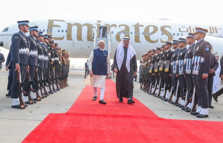 UAE President Sheikh Mohamed bin Zayed Al Nahyan walks with India’s Prime Minister Narendra Modi upon his arrival at the airport in New Delhi