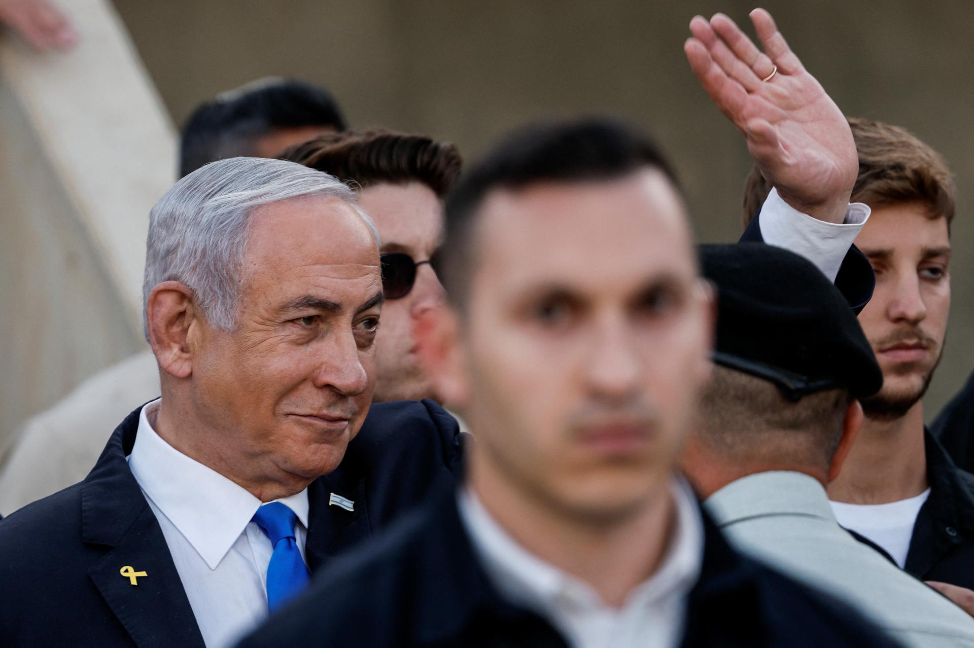 Netanyahu waves in a crowd.