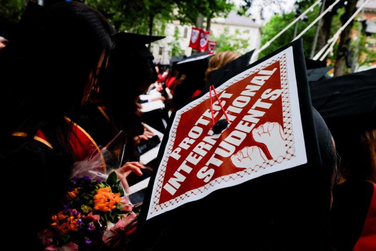 A graduating student wears their hat in solidarity for international students at Harvard University