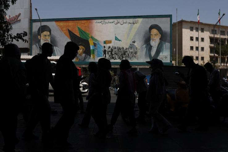 People walk past a mural depicting the late leader of the Islamic Revolution, Ayatollah Ruhollah Khomeini, and Iran’s late Supreme Leader Ayatollah Ali Khamenei, on a street in Tehran.