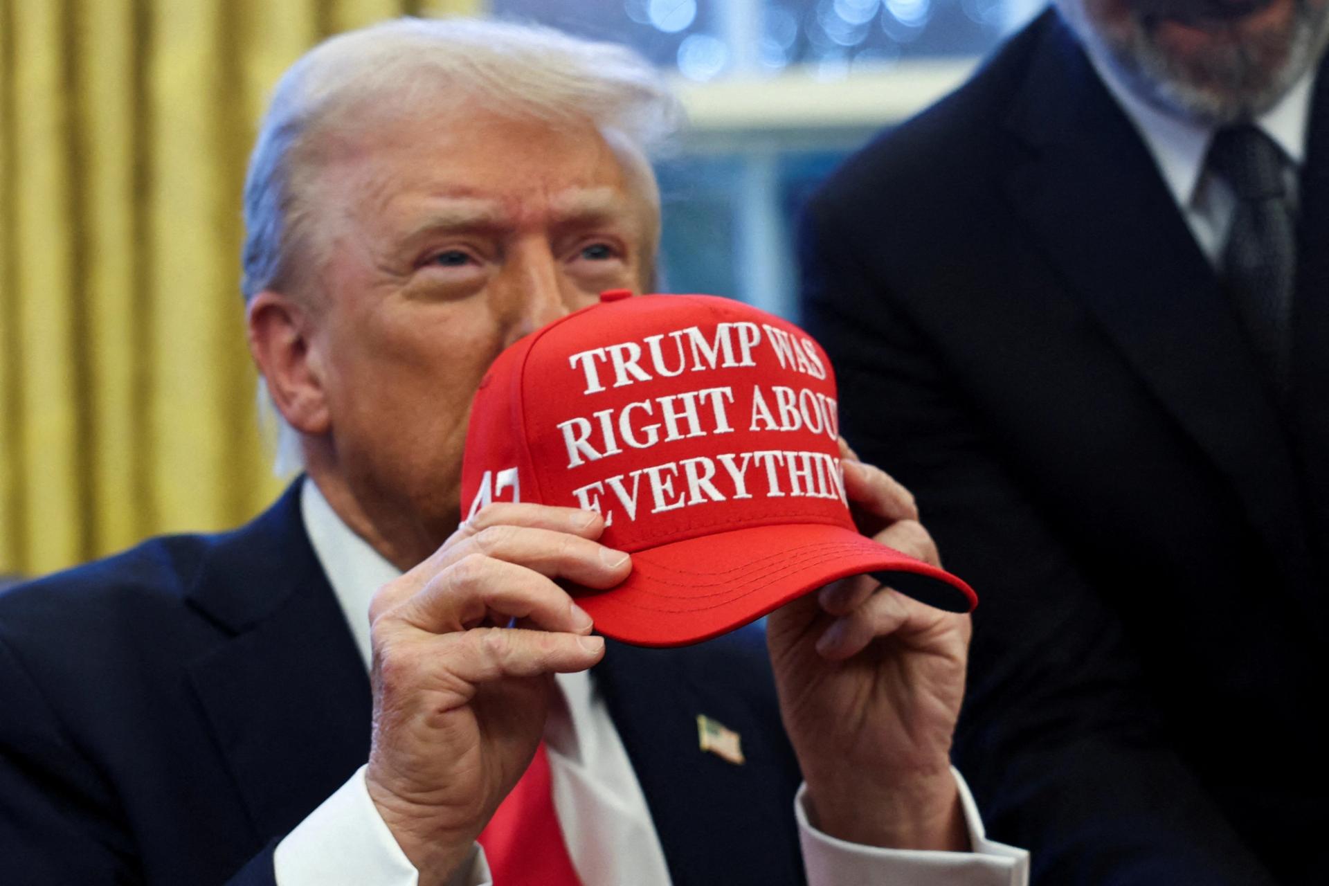 U.S. President Donald Trump holds a hat that says “TRUMP WAS RIGHT ABOUT EVERYTHING”after signing an executive order in the Oval Office.