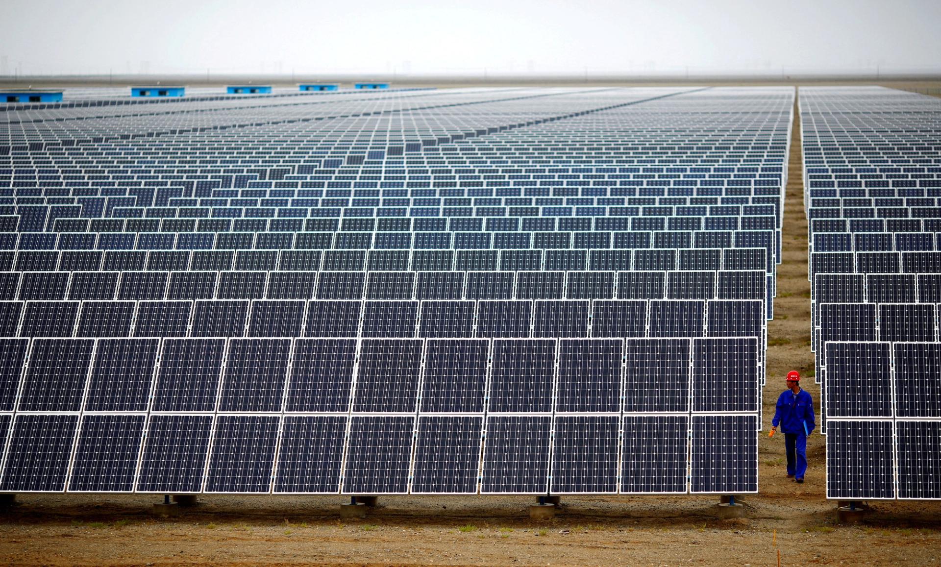 A worker inspects solar panels at a solar farm in Dunhuang, China.