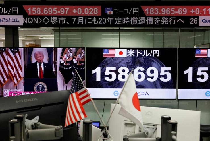 A TV screen broadcasts U.S. President Donald Trump’s speech about the Iran war next at the foreign exchange trading company in Tokyo.