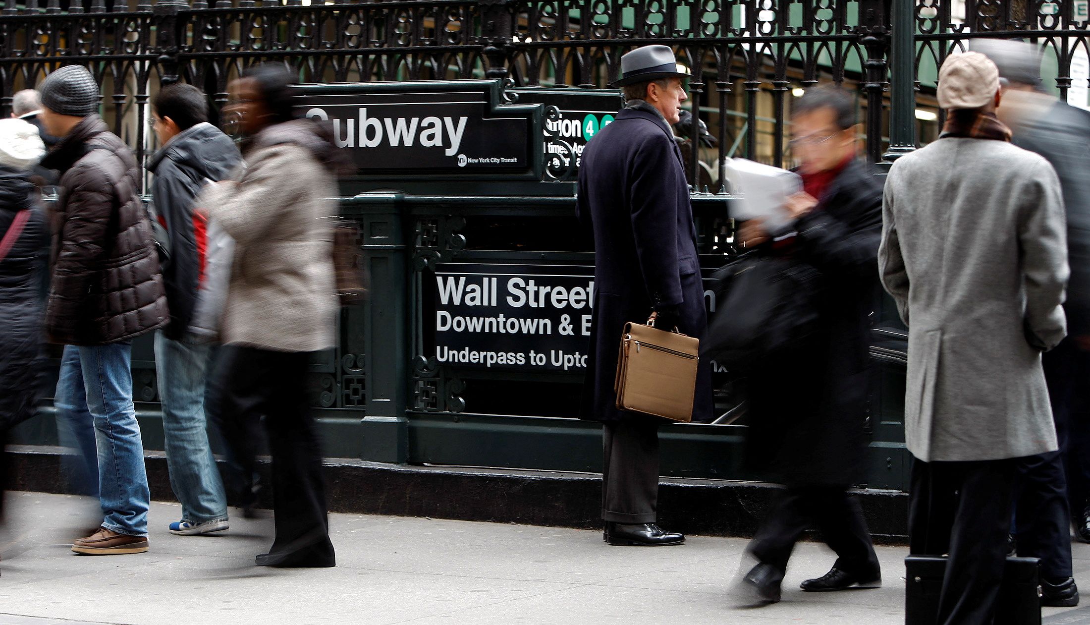 People exit from the subway to Wall Street in New York.