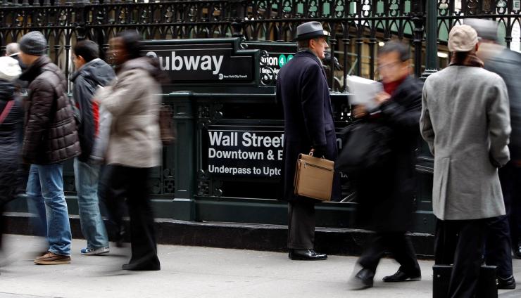 People exit from the subway to Wall Street in New York.