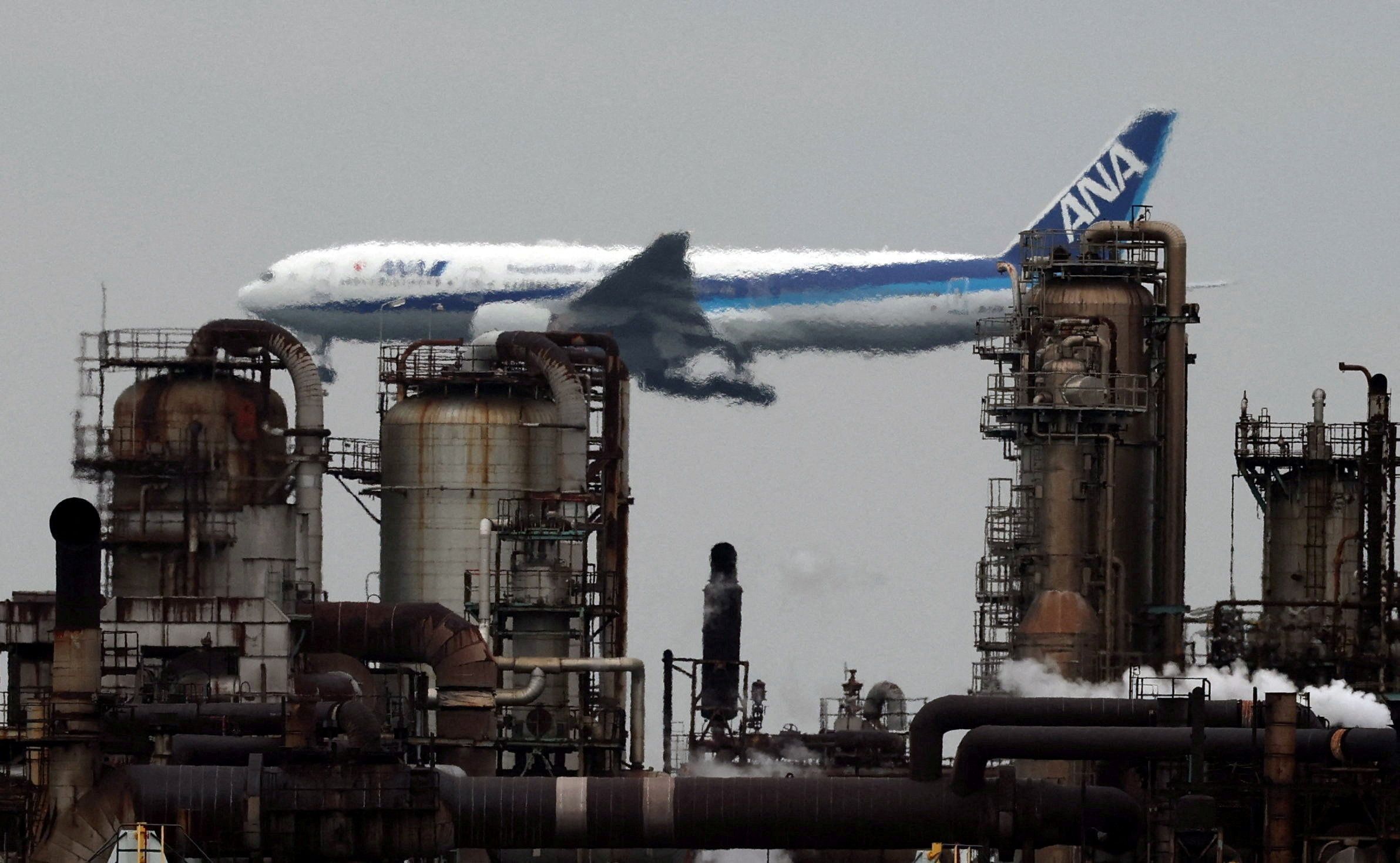 An All Nippon Airways airplane flies past an oil refinery as it approaches to land at Tokyo’s Haneda airport