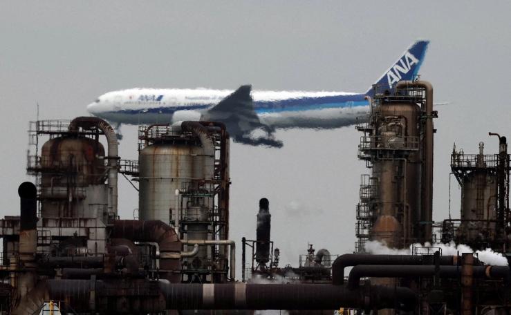 An All Nippon Airways airplane flies past an oil refinery as it approaches to land at Tokyo’s Haneda airport