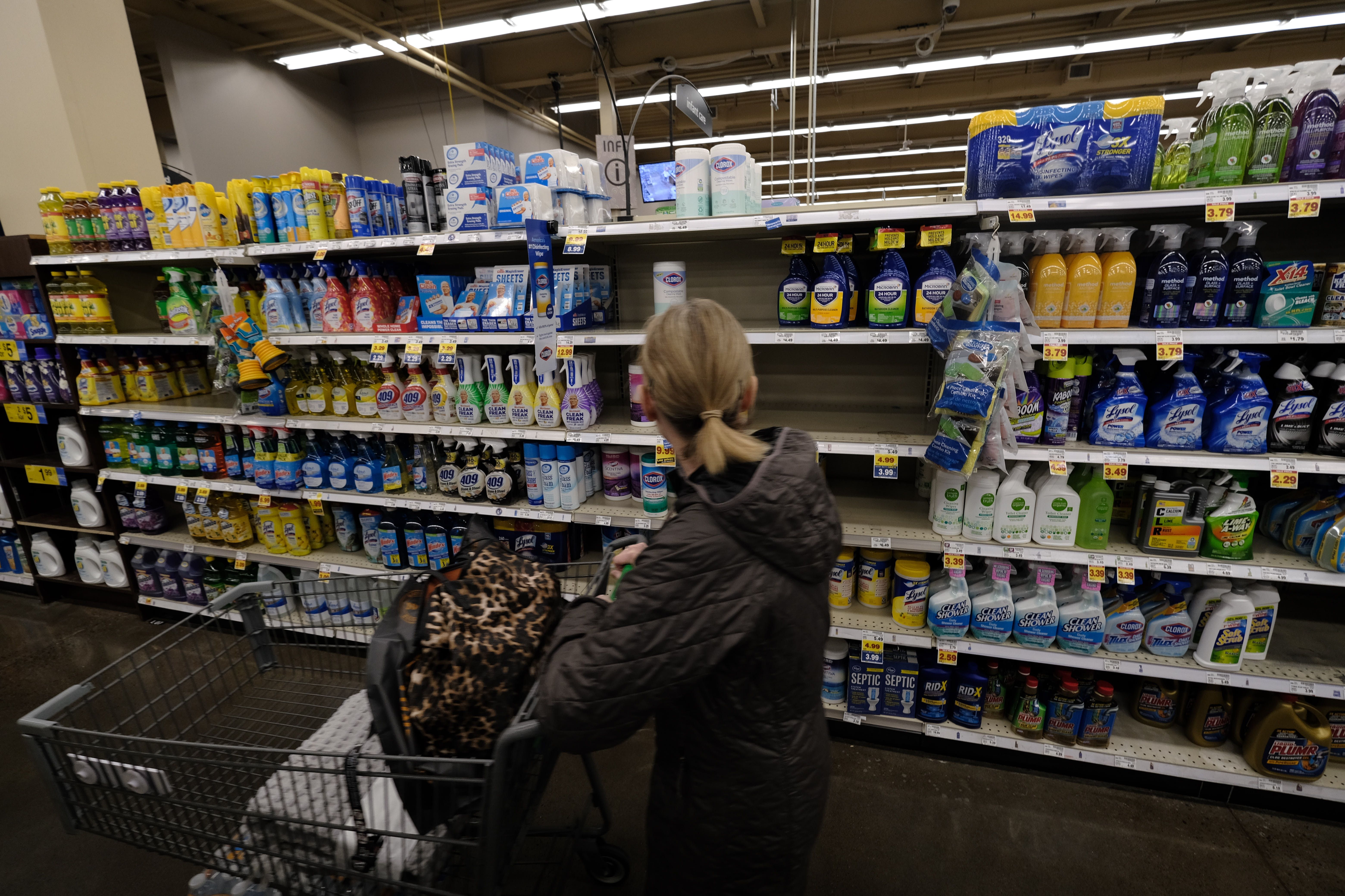 A woman looks to buy disinfectant wipes in low supply at a Fred Meyer in Portland, Ore., on March 2, 2020. 