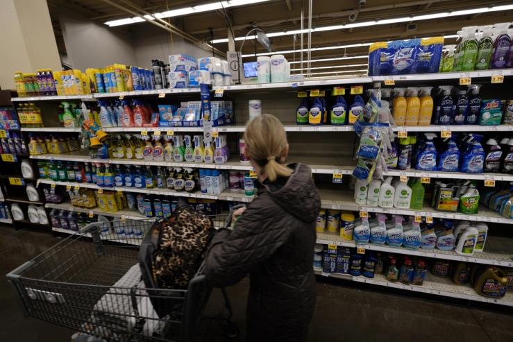 A woman looks to buy disinfectant wipes in low supply at a Fred Meyer in Portland, Ore., on March 2, 2020.