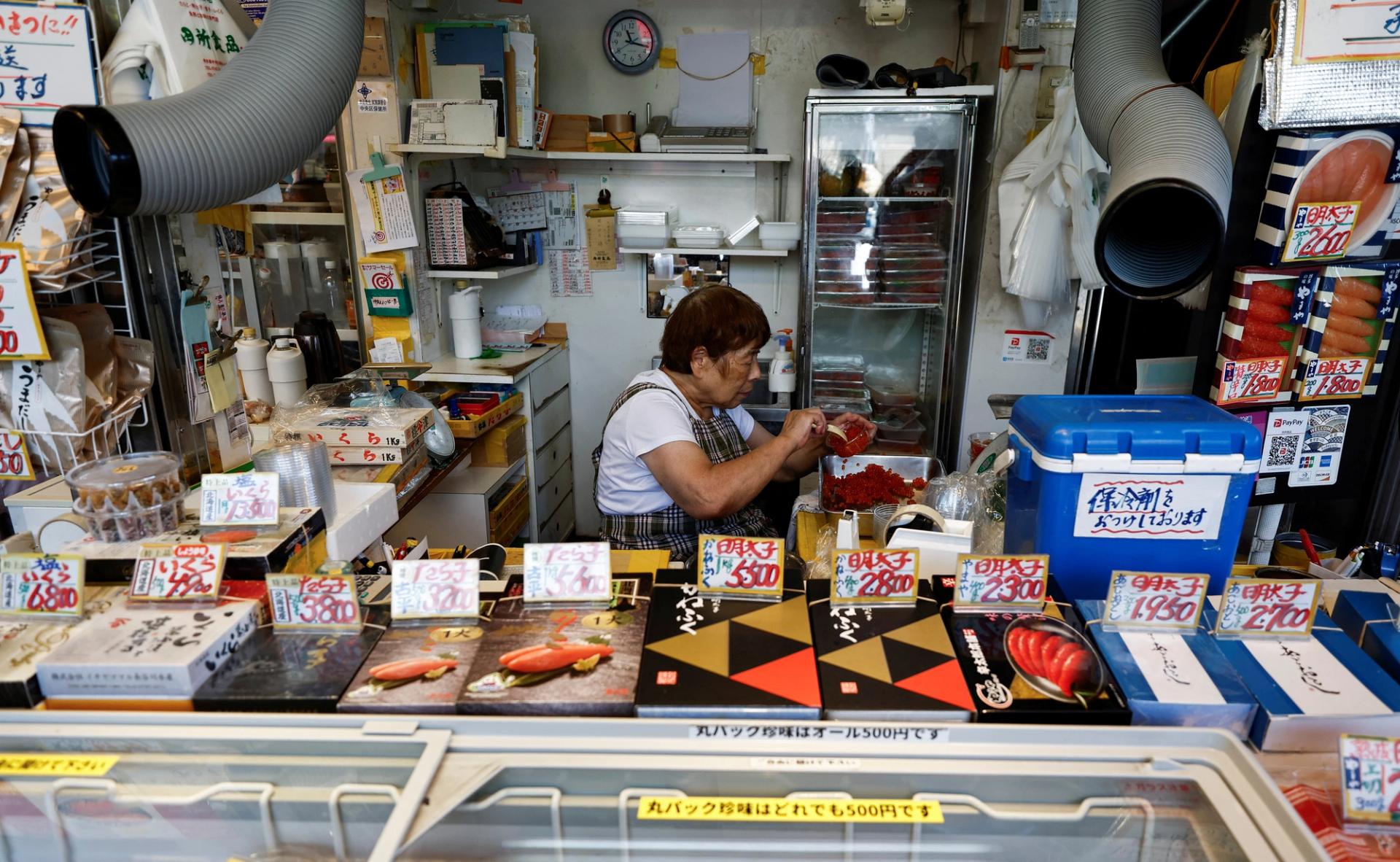 A vendor prepares food for sale inside a stall at Tsukiji Outer Market in Tokyo, Japan, 2024.