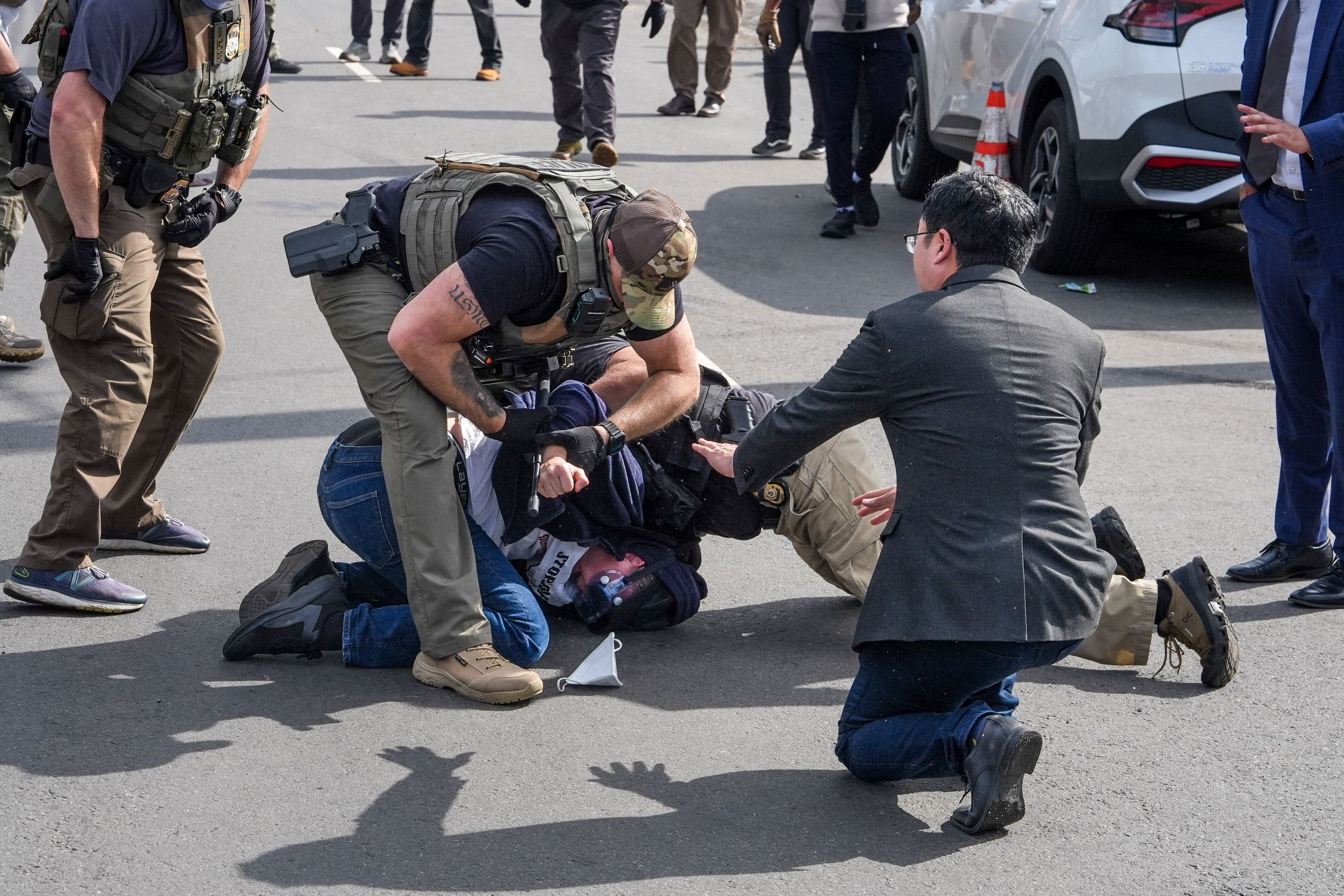 A protester is arrested as Sen. Andy Kim, D-N.J., looks on, outside the Delaney Hall detention center. 