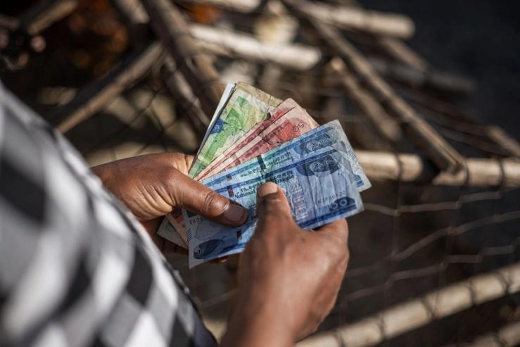 A shop owner counts Ethiopian birr in his stall at the Shola Market in Addis Ababa.