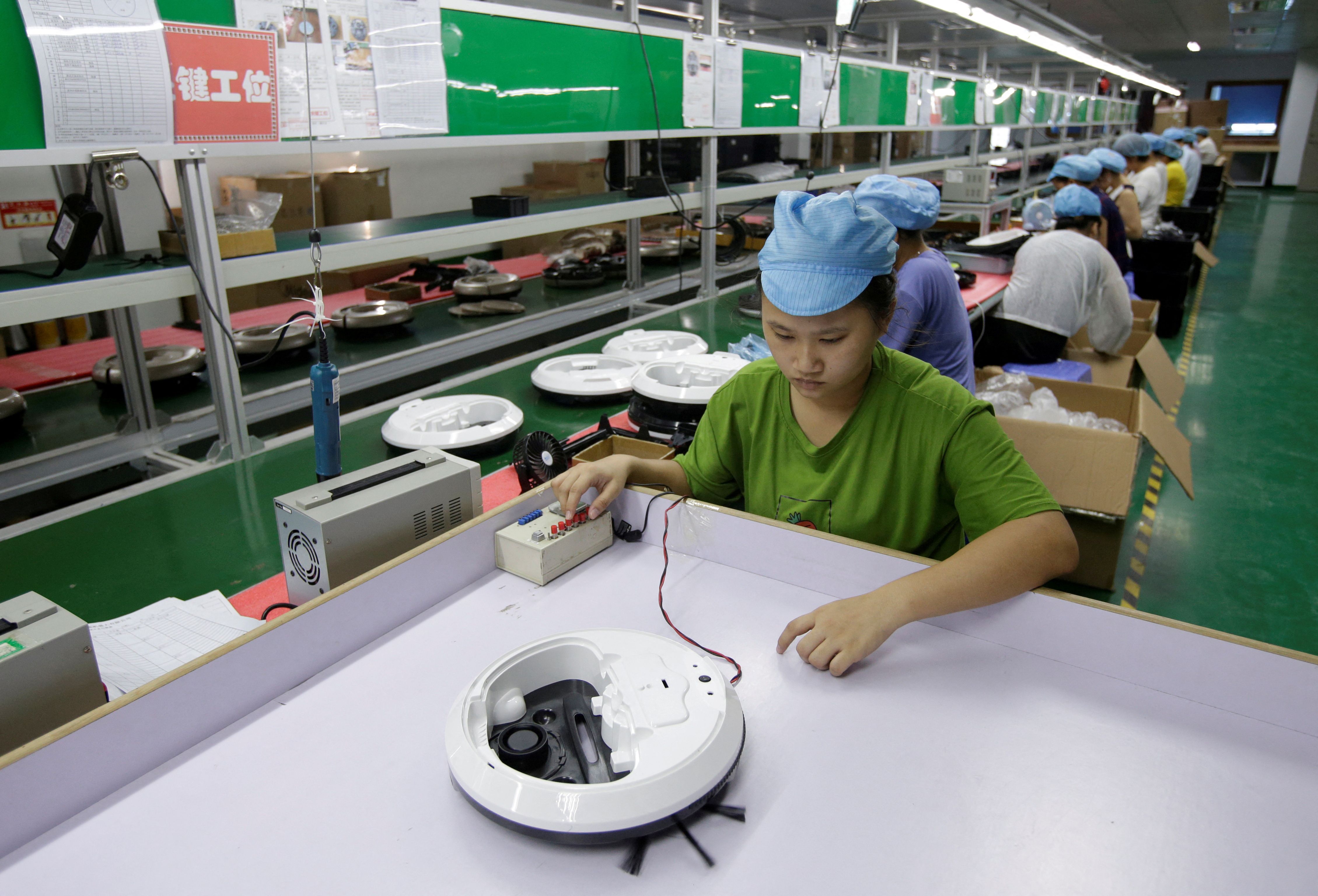 An employee works on the production line of a robot vacuum cleaner factory in Shenzhen, China