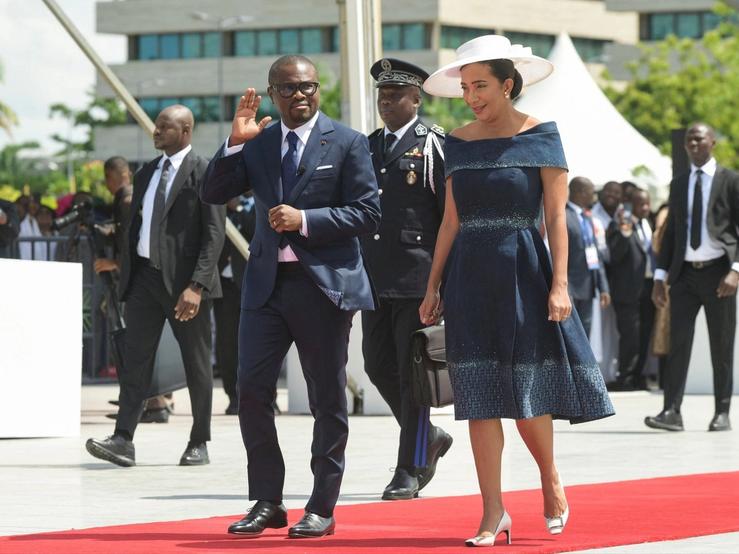 Benin’s President Romuald Wadagni waves as he walks next to his wife Nathalie Villette-Wadagni.