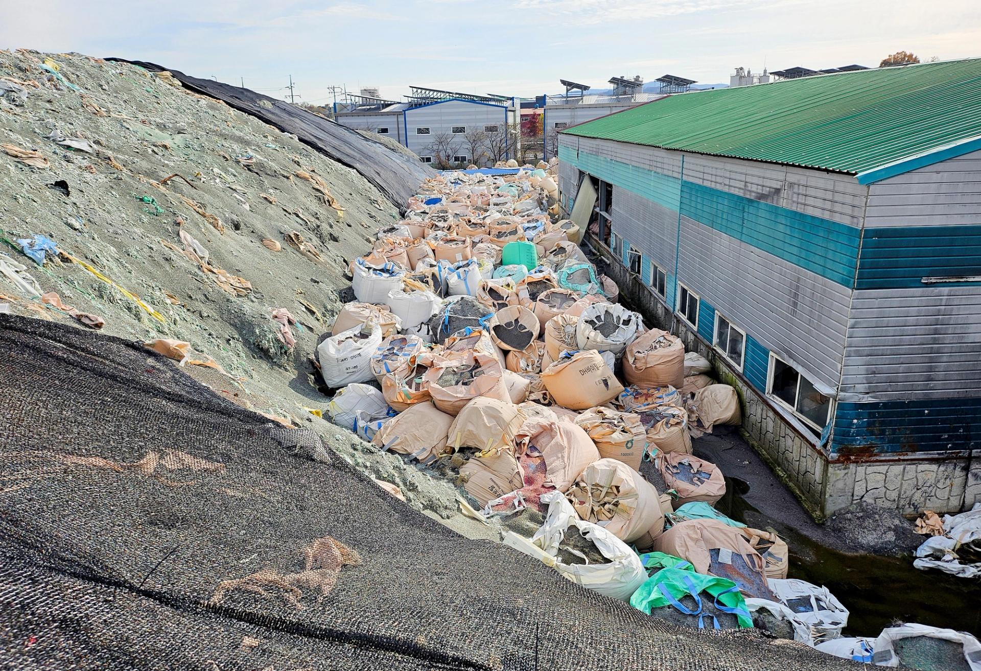 Sacks of untreated and shredded plastic waste, which is left unattended, are piled at an inoperational recycling site in Asan, South Korea.