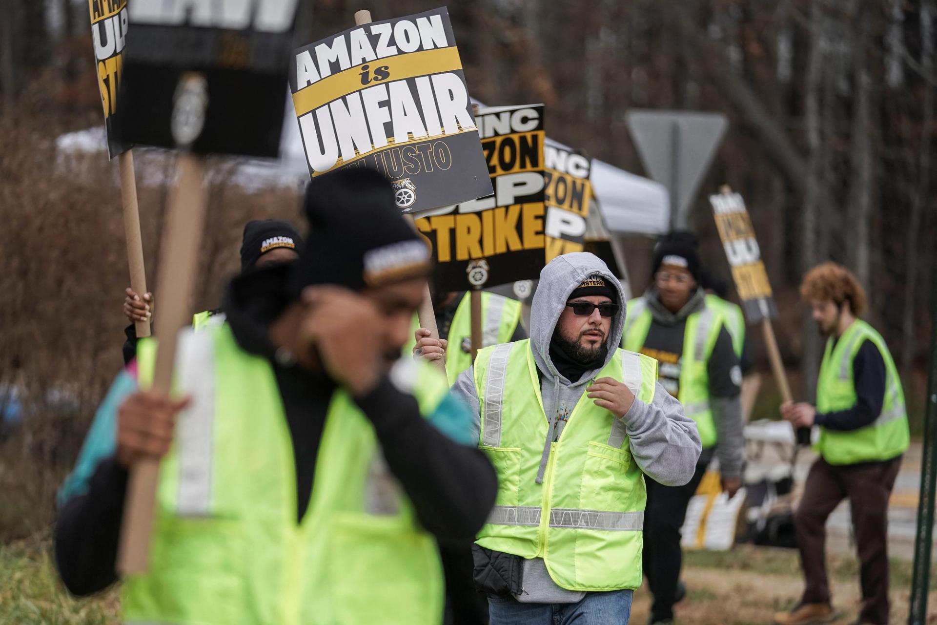 People hold signs and march during a strike by Teamsters union members.