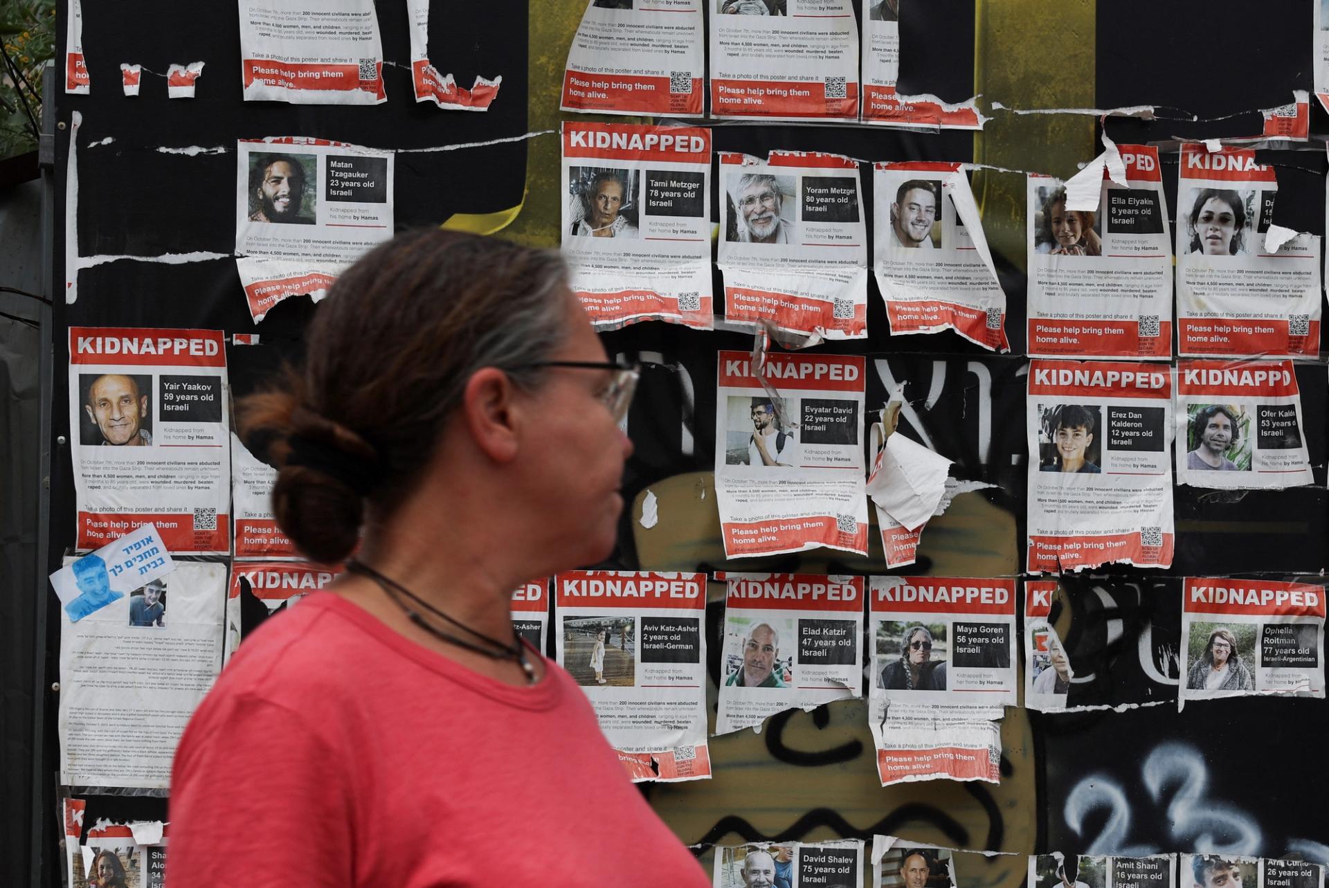 A woman walks by posters put up in support of hostages who were kidnapped during the deadly October 7 attack, amid the ongoing conflict in Gaza between Israel and Hamas, in Tel Aviv, Israel, April 30, 2024. REUTERS/Shannon Stapleton